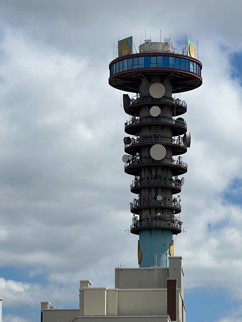 dramatic urban telecommunications tower under clouds